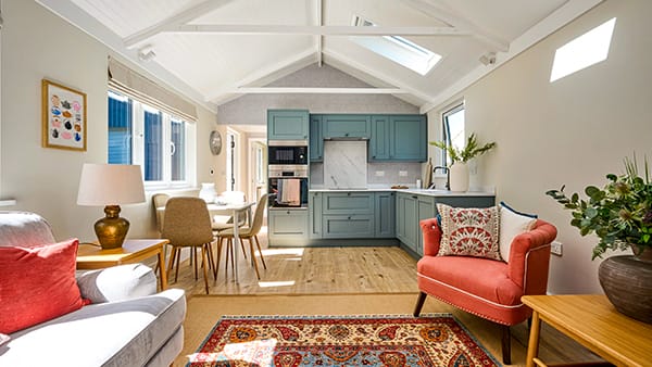 Homelodge garden annexe, Heritage range, with blue kitchen and lounge, red sofa, laminate floors, trussed ceiling